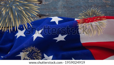 Composition of fireworks over american flag on wooden background. american patriotism and celebration concept digitally generated video.