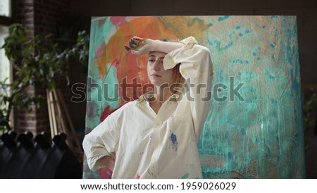Young Girl Artist Standing Near Painting.