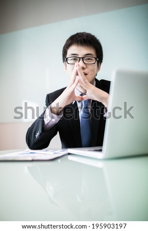 Young handsome man using laptop in his office.Asian