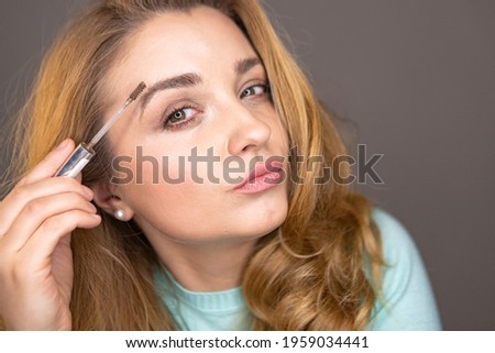 Young woman is  applying makeup. Make-up blogger testing decorative cosmetics in front of the camera