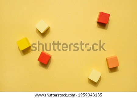 Yellow geometrical figures still life composition. Wooden game cube objects on yellow background. Platonic solids figures, simplicity concept top view with shadow