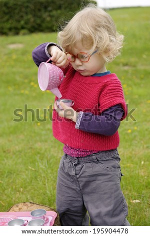 little toddler playing  tea time in the garden