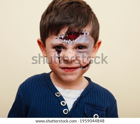 little cute child with facepaint on birthday party, zombie Apocalypse facepainting, halloween preparing concept, lifestyle people