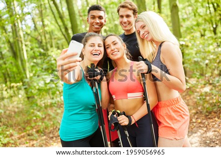 Group of friends takes a selfie photo during a Nordic walking excursion in summer