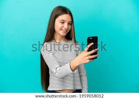 Little girl over isolated blue background making a selfie