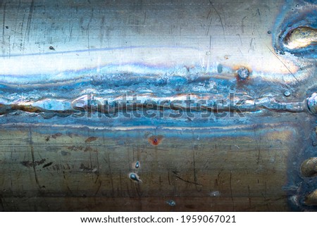 A piece of grunge rusty steel pipe with horizontal welds lines and traces. Aged vintage steampunk shiny piece od metal with scratches, stains from welding. Royalty-Free Stock Photo #1959067021
