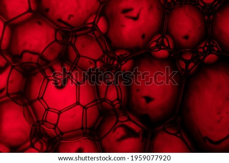 A closeup shot of soap bubbles under red light