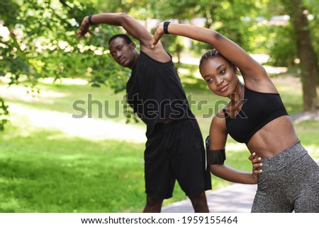 Sporty African Couple Doing Fitness Workout Together In Summer Park, Stretching Muscles, Free Space