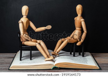 Two people sit opposite each other and talk