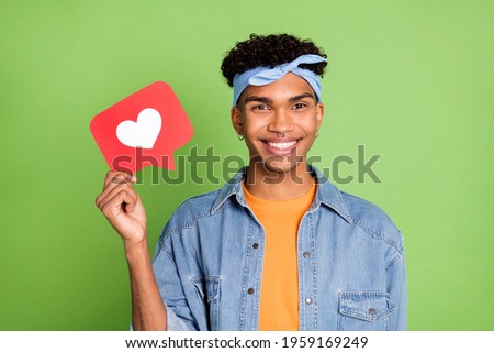 Photo portrait of handsome guy smiling showing like sign in social media icon isolated bright green color background