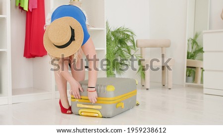 A young woman is packing a suitcase for a trip