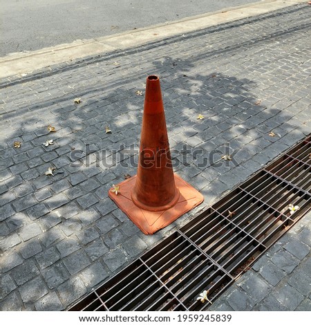 Orange traffic cones that are used in old condition. Was left on a road.