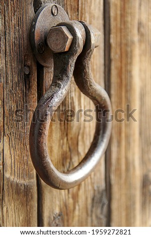 Old antique metal handle on a rough wooden door, handmade, close-up, shallow depth of field