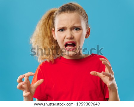 upset girl gesturing with her hands and yelling on a blue background red t-shirt model