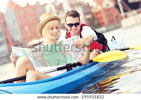 A picture of a young couple with a map in a canoe