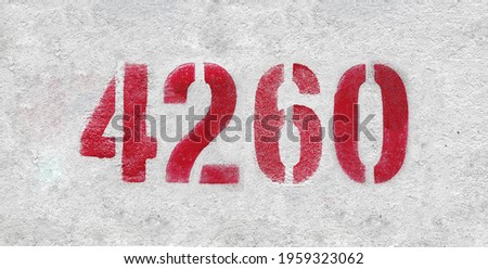 Red Number 4260 on the white wall. Spray paint.