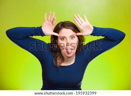 Closeup portrait funny, foolish, young, childish rude bully woman sticking tongue out at you camera gesture, isolated green background. Human emotions, facial expressions, feelings. Signs, symbols