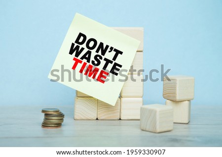 the words DONT WASTE TIME is written on the sticker , a wooden cubes structure. Can be used for business, MEDICINE, financial concept. Selective focus.