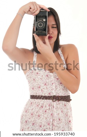 Attractive girl with a camera over white background