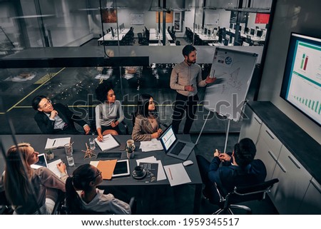 Business presentation. A group of handsome business people working in a spacious conference room in a large business center. Concept of startup, projects, planning, results, strategy. Royalty-Free Stock Photo #1959345517