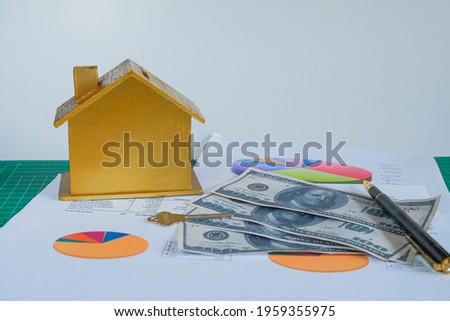 Golden house with banknotes on business chart paper  ,business concept.
