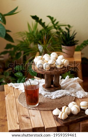 Homemade macaroons on wooden background with glass of tea
