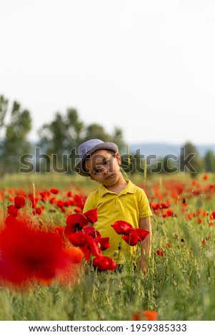 It's spring time. The boy is very happy in the poppy flower field. Antalya, Turkey.