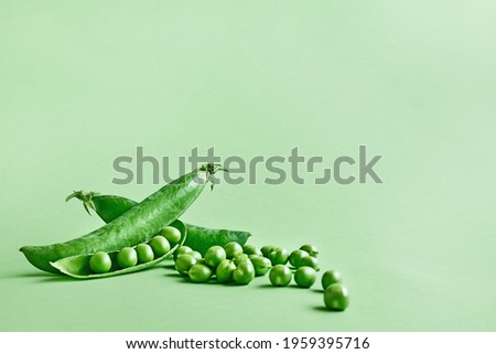 Minimal food creative concept. Fresh green peas on light green pastel background Royalty-Free Stock Photo #1959395716