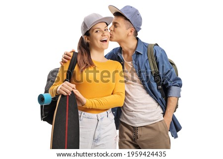 Male student kissing a female skater with a longboard isolated on white background