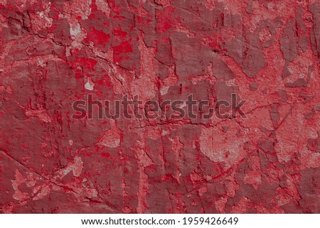 Grunge red concrete background. Textured plaster wall. Color of the year 2021 concept. Top view, layout for design. Surface with peeling shabby pattern.