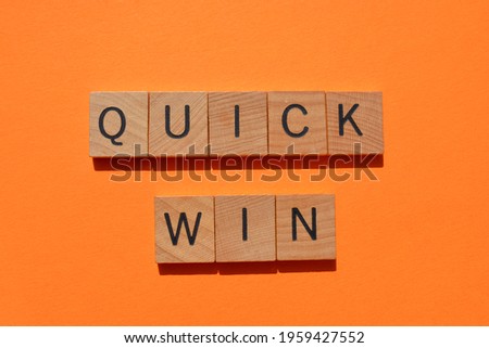 Quick Win, words in wooden alphabet letters isolated on orange background