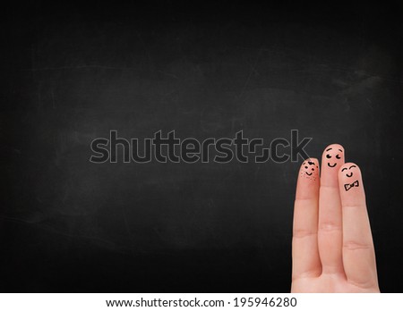 Happy cheerful smiley fingers looking at empty black chalboard