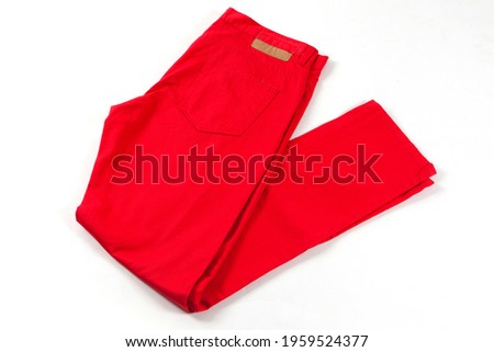 Red jeans pants isolated on white background. Folded casual style trousers  Royalty-Free Stock Photo #1959524377