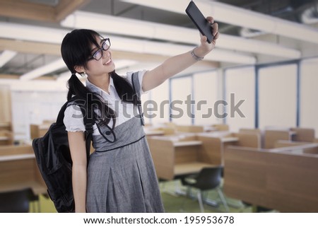 Attractive female student taking self portrait in the class