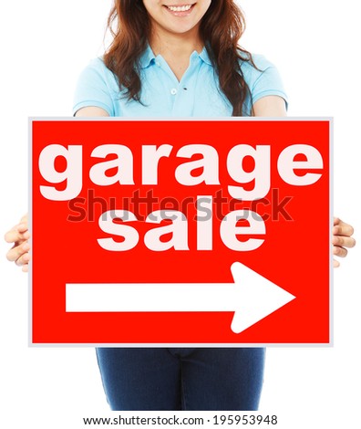 A young woman holding a signboard indicating Garage Sale 