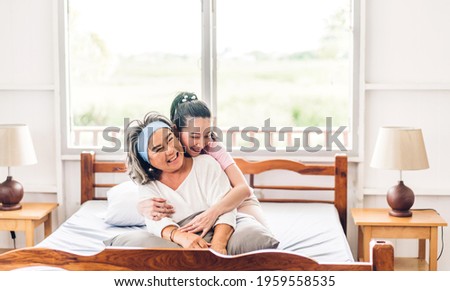 Portrait of enjoy happy love asian family senior mature mother and young daughter smiling laughing embracing and having fun hug together in moments good time at home