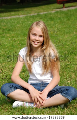 A beautiful teenagers girl seating on the grass