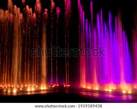 Large multi colored decorative dancing water jet led light fountain show at night 