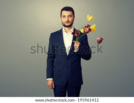 handsome man with faded flowers over dark background