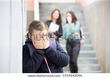 Girl being bullied at the school. Educational school isolation and bullying concept.