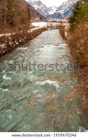 Linth river with blue and green transparent waters flowing near the town of Linthal in the Swiss alps
