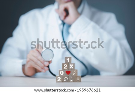 Close Up doctor or scientist in uniform wearing a face mask with a stethoscope and touch wood cubes with Medical treatment icon white background, Healthcare And Medical concept, medicine, and people.