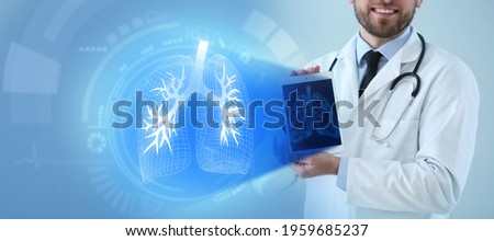 Male doctor holding tablet computer and virtual screen with picture of lungs on color background