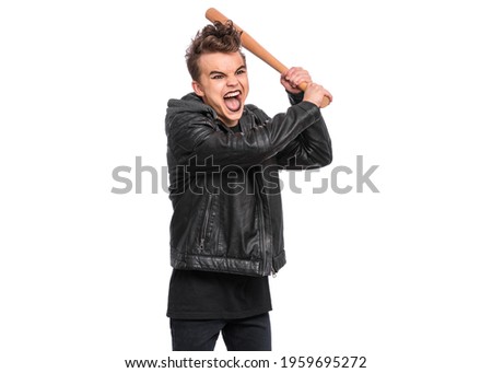 Rebellious teen boy dressed in black, isolated on white background. Young teenager in style of punk goth wearing leather jacket, holding wooden bat. Problems of transitional age