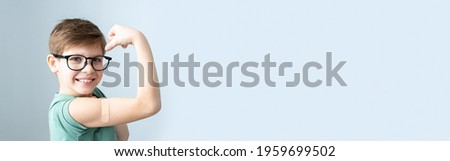 Boy with patch on hand, vaccinated against coronavirus infection. Vaccination against covid-19. Sputnik-V. banner, Copy space. Royalty-Free Stock Photo #1959699502