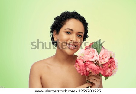 beauty and people concept - portrait of happy smiling young african american woman with flowers over lime green natural background