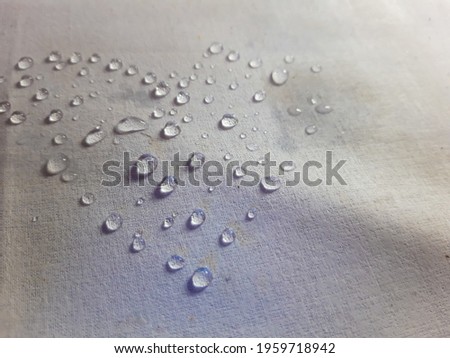 Water drop on the white cotton fabric for background or wallpaper