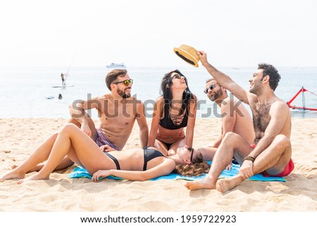 Happy friends relaxing on the beach in Barcelona - Multiracial group of best friends enjoying summer time together and having fun - Happiness and friendship during a travel in Spain