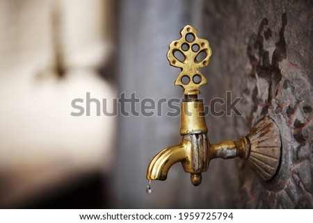 Antique brass faucet in Wudu (Ablution) space in courtyard of Mevlana Jalal ad-Din Mu?ammad Rumi’s shrine – Konya. Royalty-Free Stock Photo #1959725794