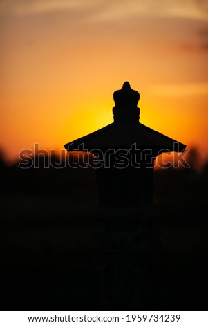 Silhouette of a temple where offerings are made in a rice field in Bali